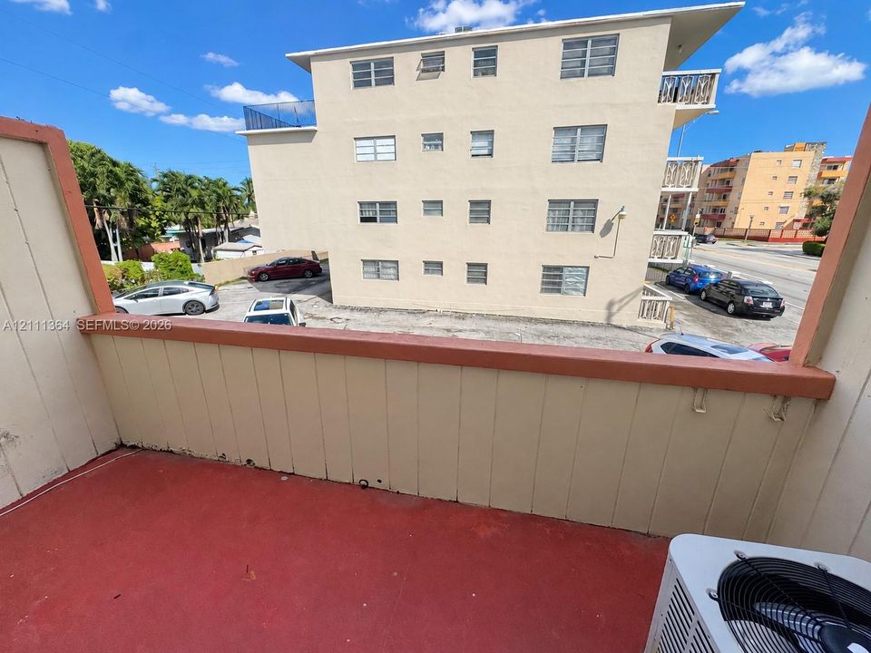 Private balcony featuring painted concrete flooring, vertical siding, and a solid railing