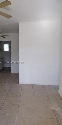 Interior space featuring ceramic tile flooring, neutral wall finishes, and a ceiling-mounted fan