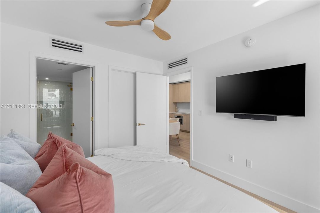 Minimalist room featuring a three-blade wooden ceiling fan, neutral wall finishes, and integrated recessed lighting fixtures