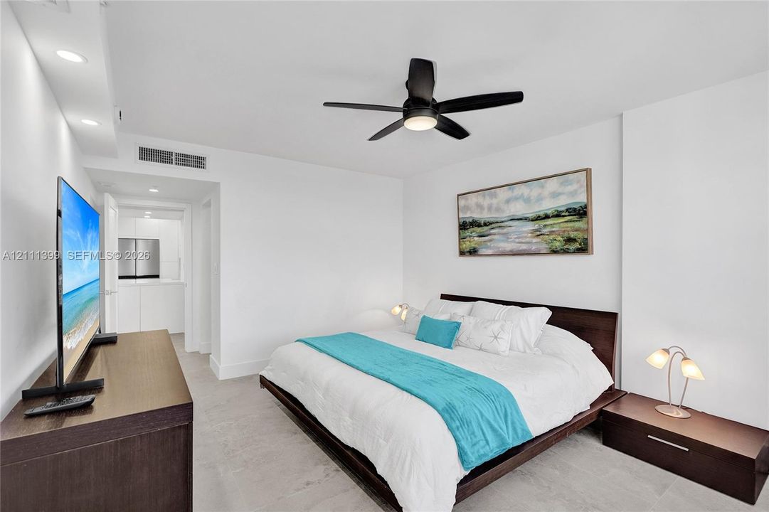 Neutral interior featuring light-toned flooring, recessed ceiling lighting, and a modern black multi-blade ceiling fan