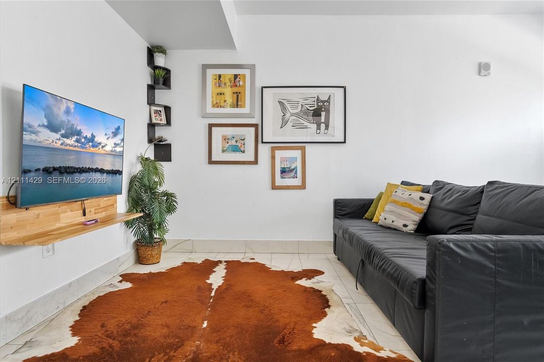 Wall-mounted natural wood-finish floating shelf, corner-mounted black display shelving, and light-toned tile flooring
