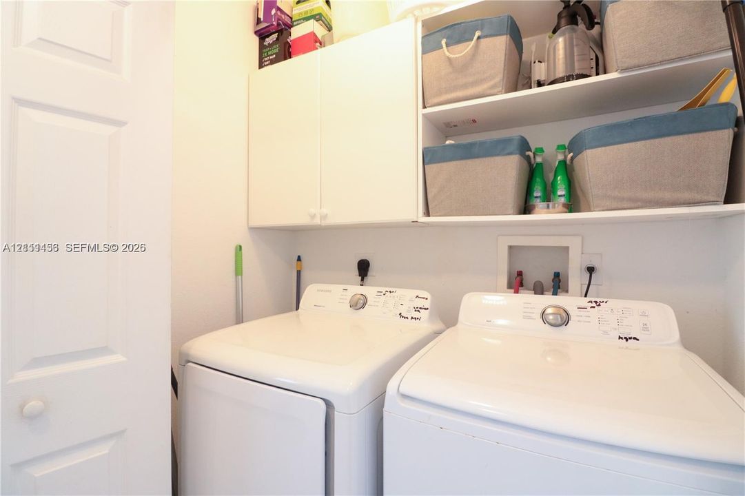 Laundry area featuring white built-in cabinetry and open shelving