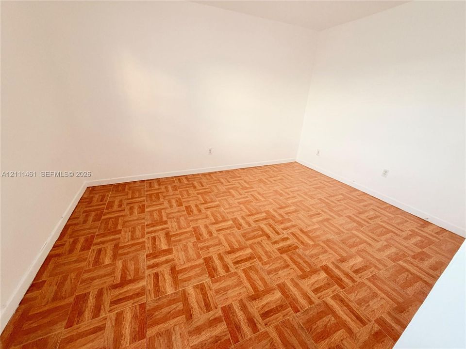 Interior space featuring parquet wood-finish flooring and neutral white walls