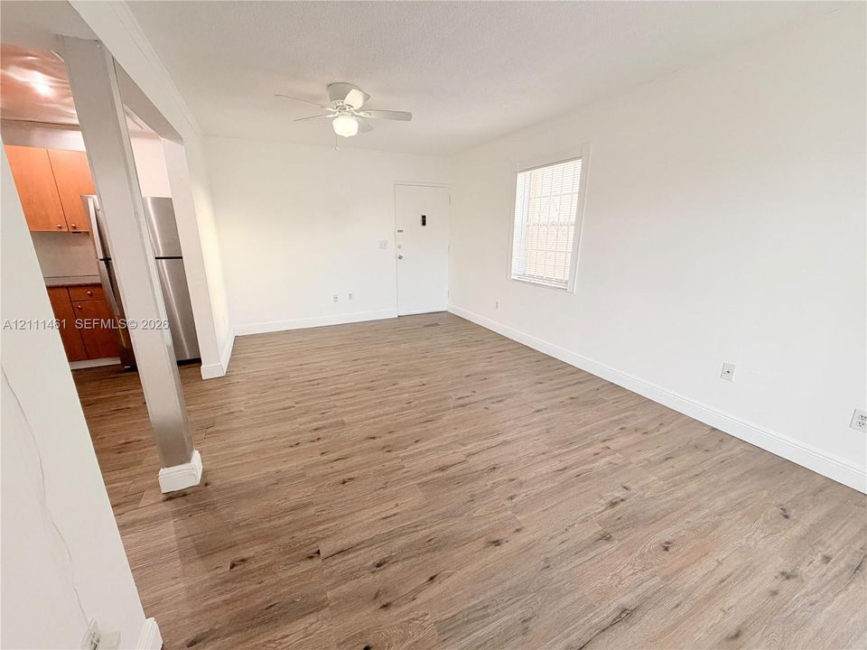 Interior space featuring wood-finish flooring, a ceiling fan, and white walls