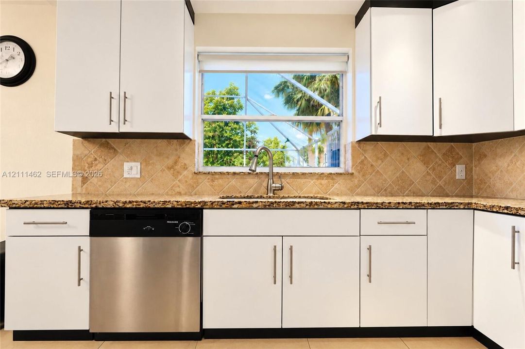 Kitchen featuring white cabinetry, stone-finish countertops, diagonal-set stone backsplash, stainless steel dishwasher, and stainless steel gooseneck faucet
