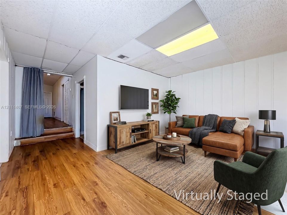 Wood-finish flooring, vertical plank wall paneling, and recessed ceiling lighting