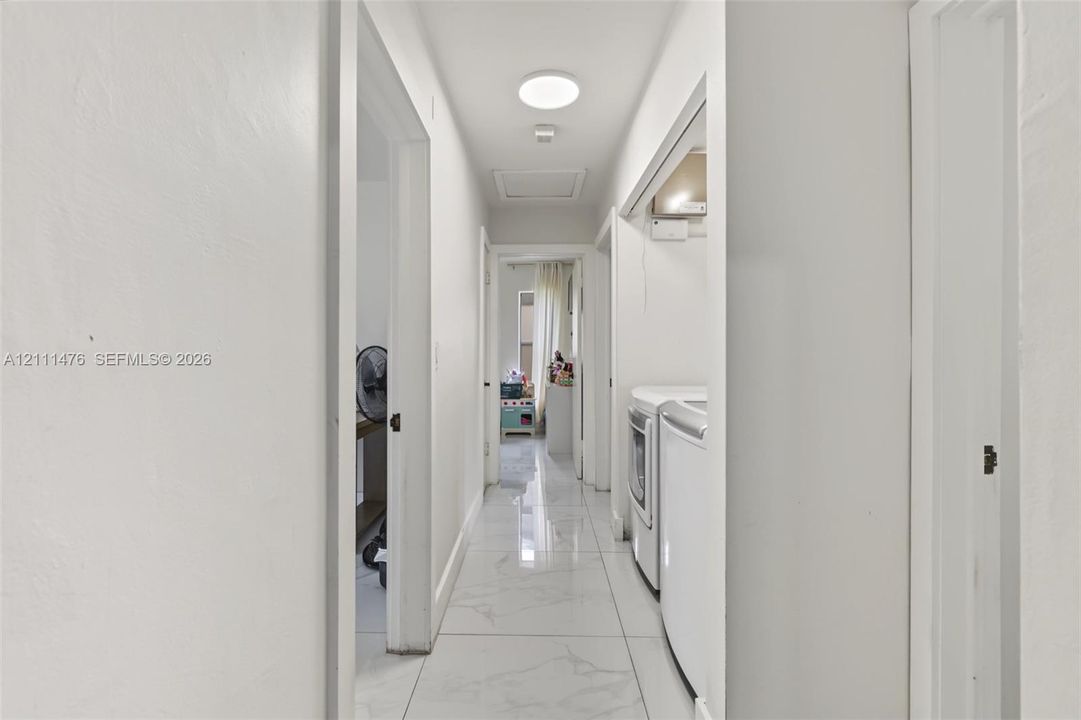 Interior hallway featuring large-format stone-look tile flooring and a flush-mount circular ceiling light