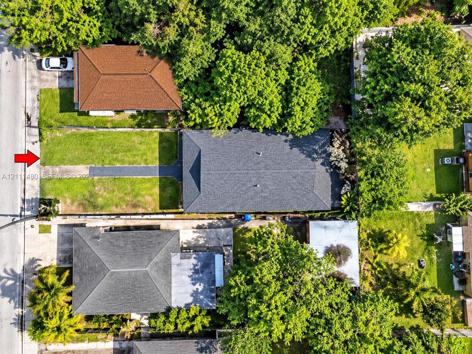 Rectangular lot featuring a paved concrete driveway and established perimeter landscaping