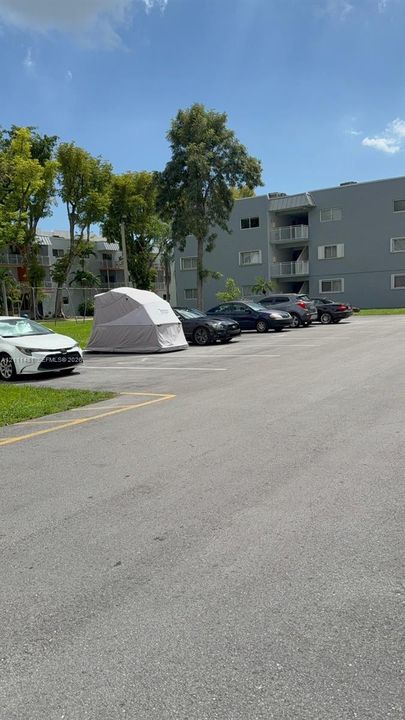 Exterior parking area with paved surface and mature landscaping