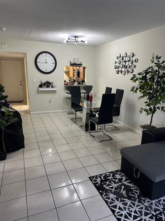 Ceramic tile flooring, multi-arm flush-mount ceiling light fixture, and pass-through opening