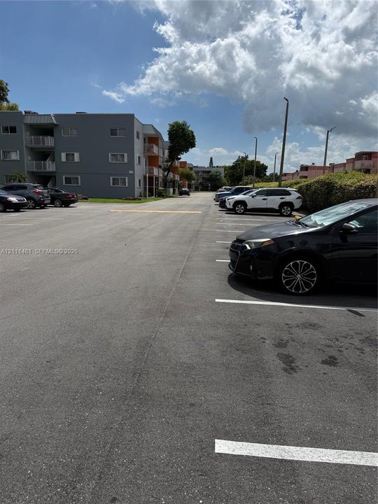 Asphalt surface parking lot featuring designated stall markings and pole-mounted exterior lighting