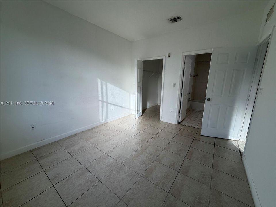 Interior space featuring ceramic tile flooring, neutral wall tones, multi-panel doors, and an integrated closet