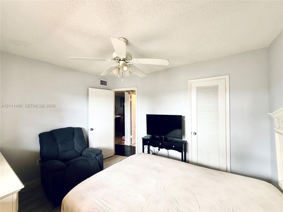 Room featuring a multi-speed ceiling fan with integrated lighting and a louvered closet door