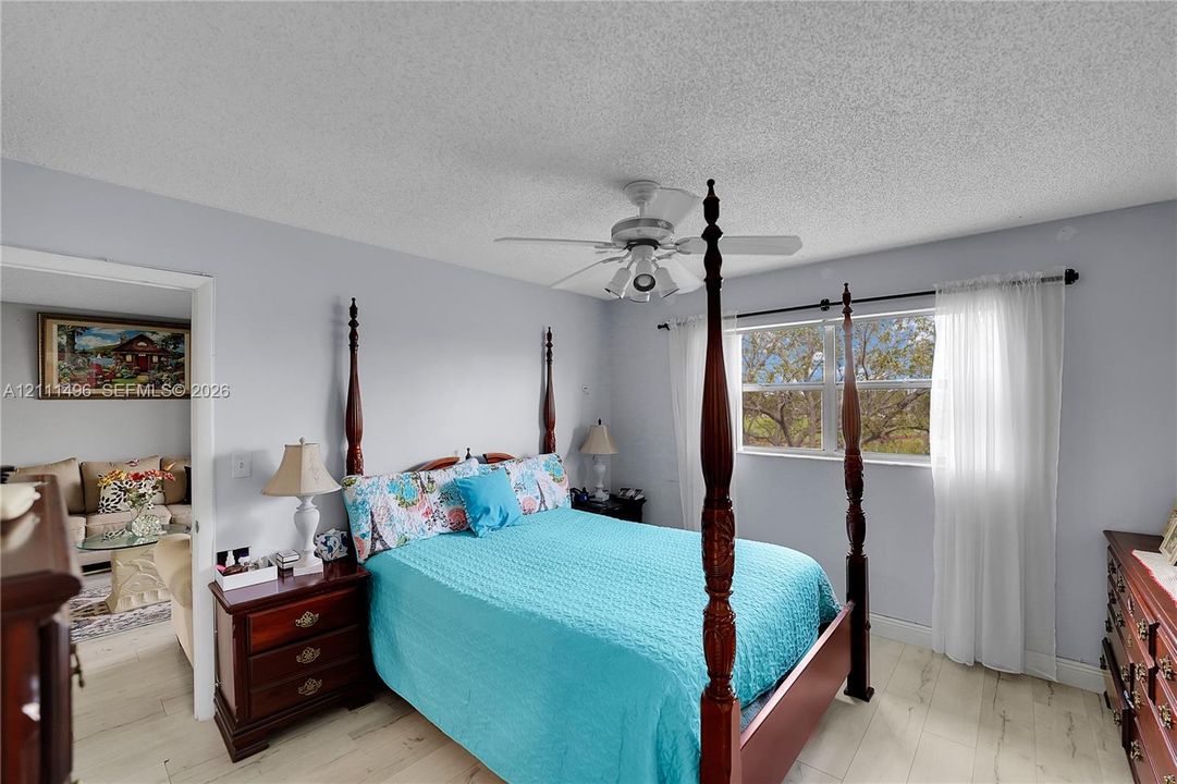 Neutral wall tones, light-finish wood-look flooring, and a multi-blade ceiling fan with integrated lighting