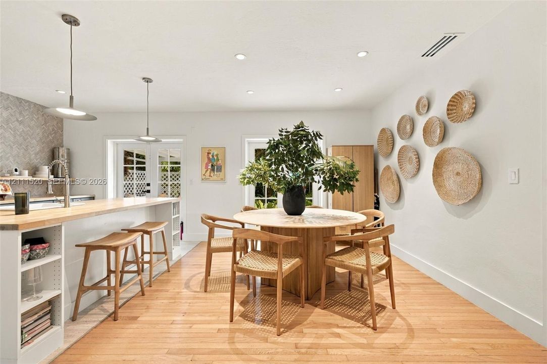 Kitchen featuring wood-finish flooring, a breakfast bar with wood countertop, recessed lighting, pendant fixtures, and a herringbone-patterned backsplash