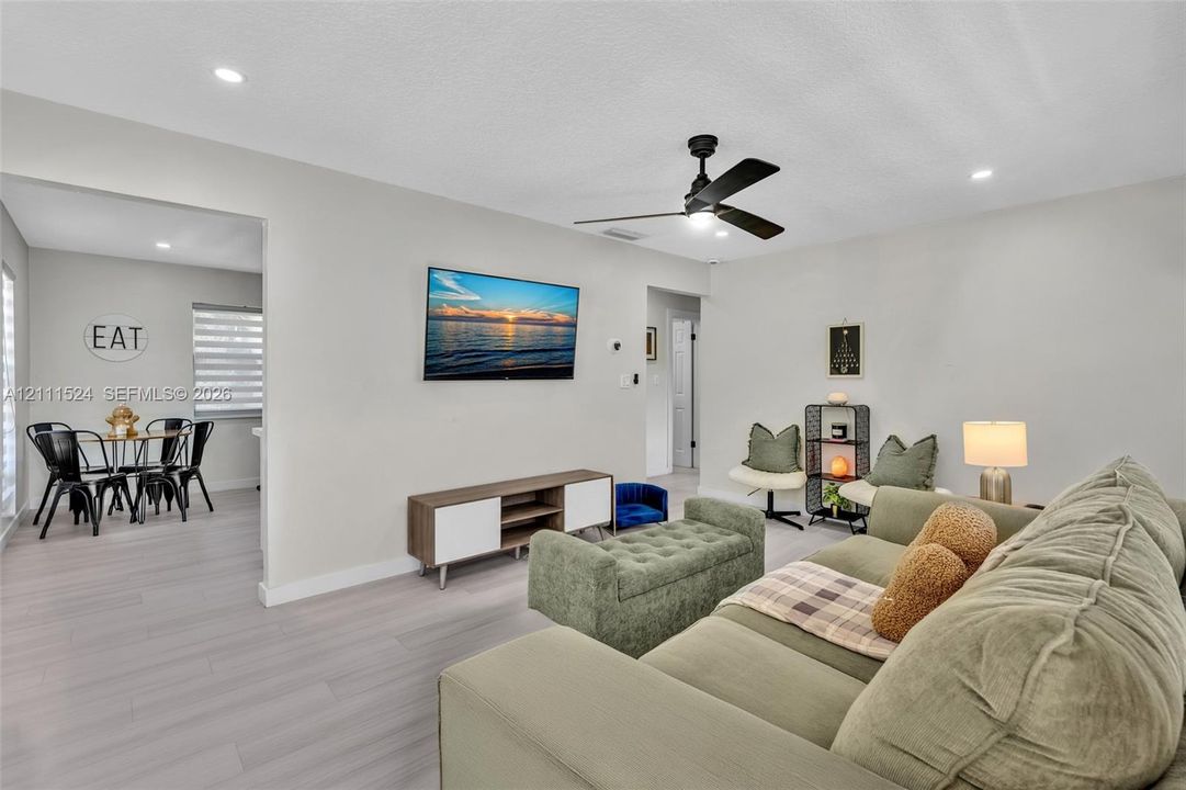 Light-toned wood-finish flooring, recessed lighting, and a modern ceiling fan