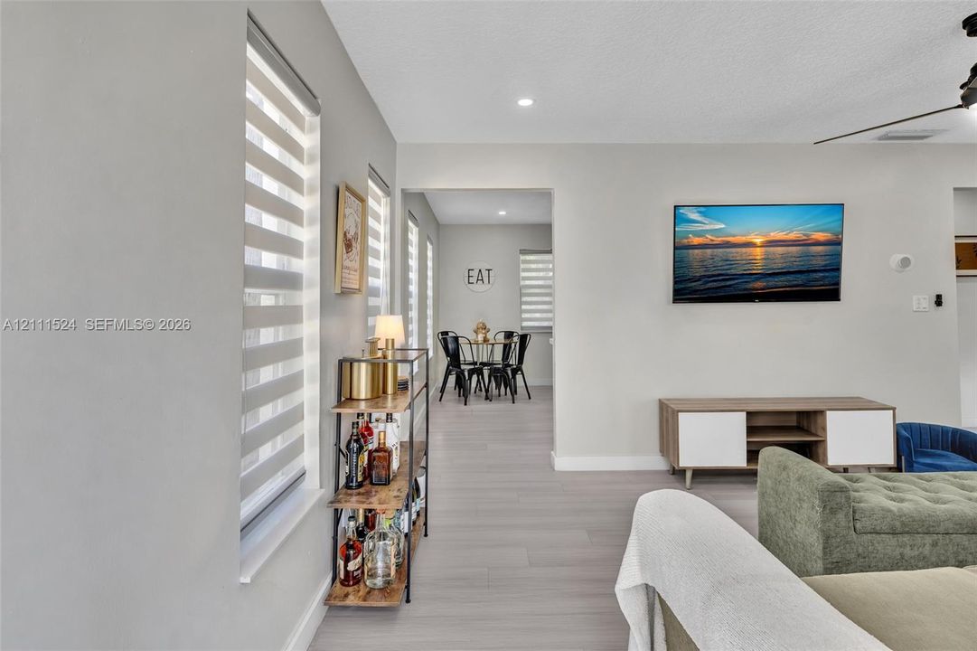Neutral-toned interior featuring wood-finish flooring, recessed lighting, and dual-layered horizontal blinds