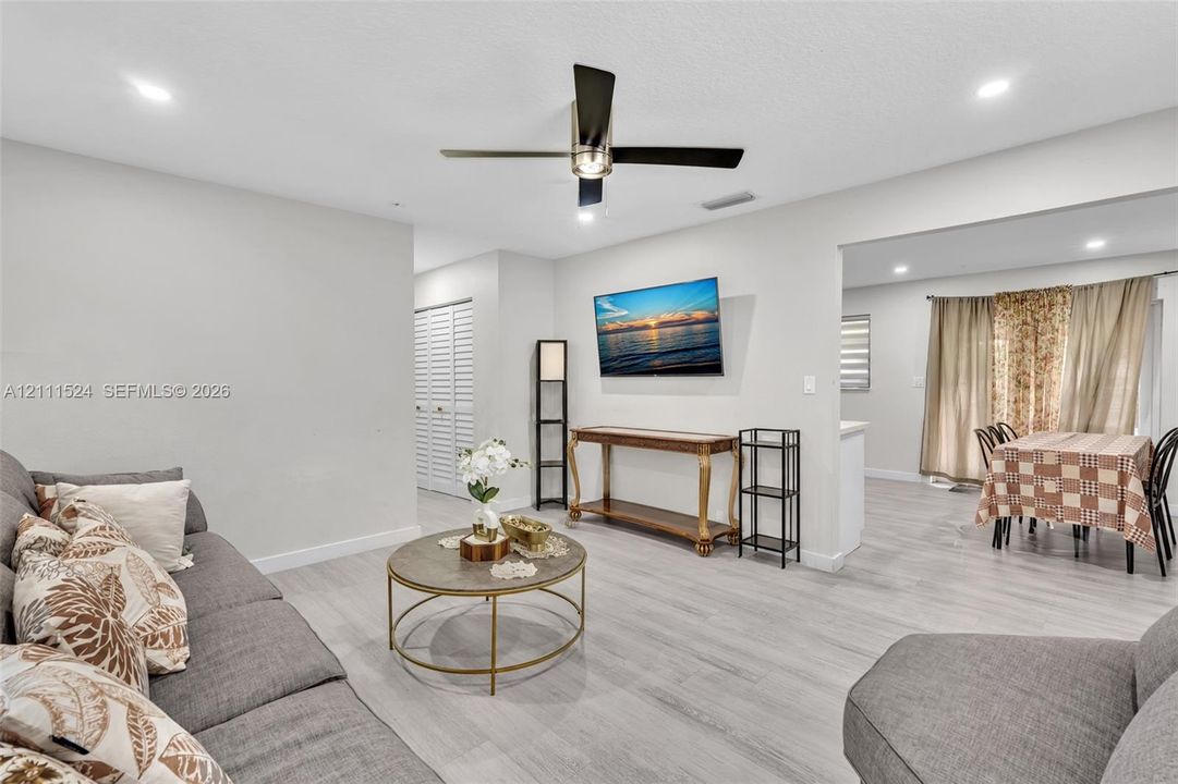 Neutral-toned interior featuring wood-finish flooring, recessed lighting, and a modern ceiling fan