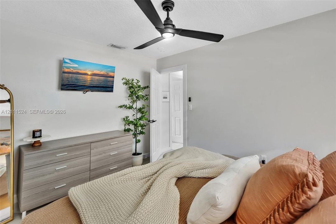 Matte black ceiling fan with integrated lighting and interior door with a paneled design