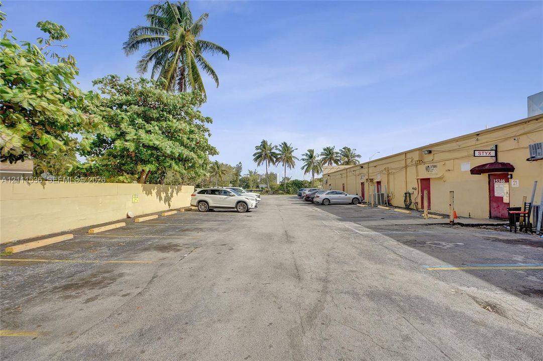 Dedicated asphalt parking area with marked stalls and perimeter wall enclosure