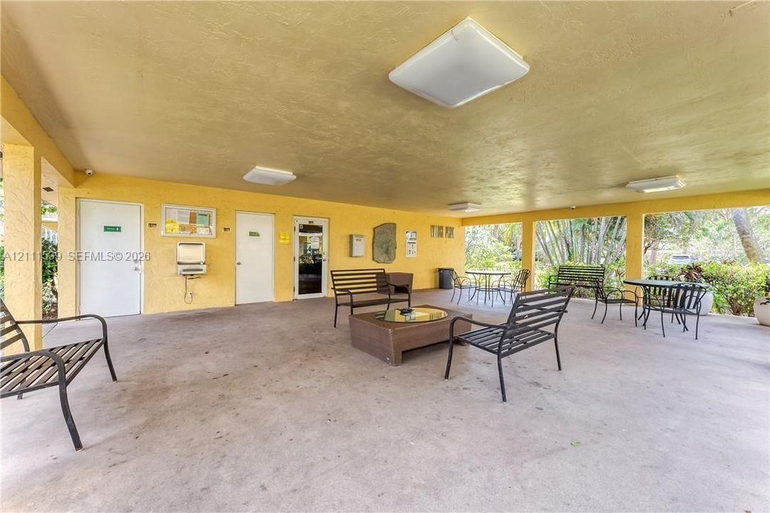 Covered outdoor patio featuring a concrete floor, flush-mount ceiling lighting, and multiple access points