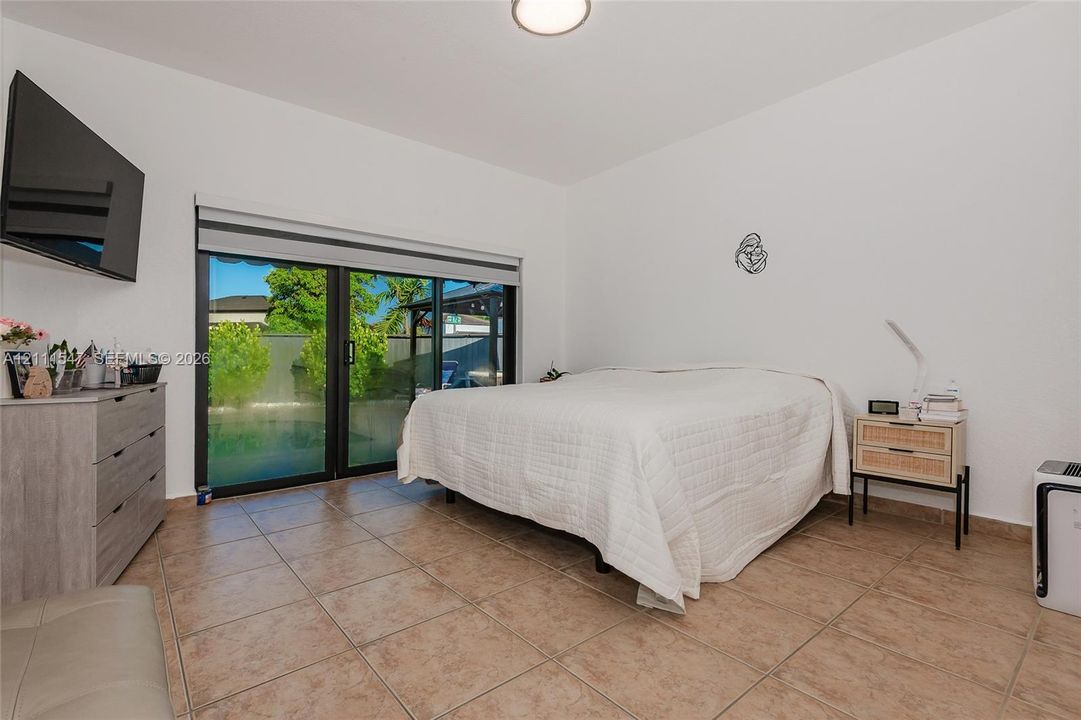 Ceramic tile flooring, black-framed sliding glass doors, and flush-mount overhead lighting