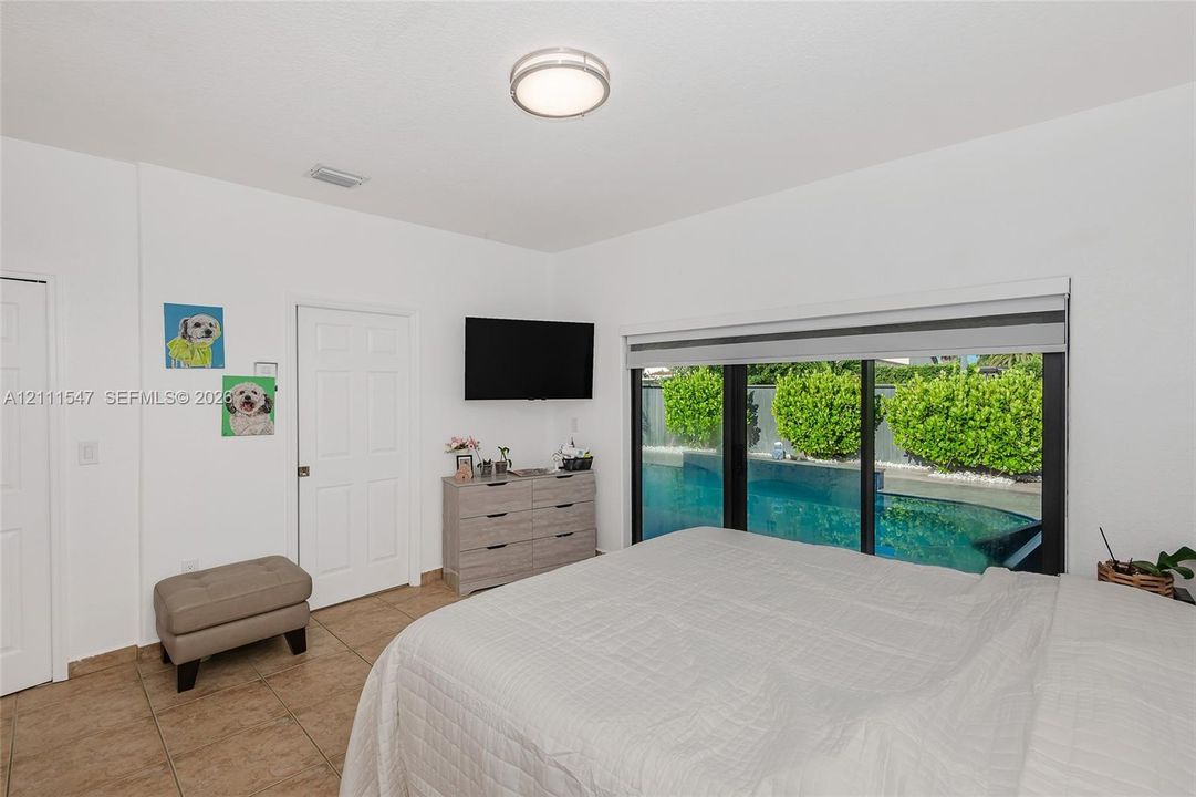 Tile flooring, flush-mount ceiling lighting, multi-panel doors, and large sliding glass doors featuring exterior pool access