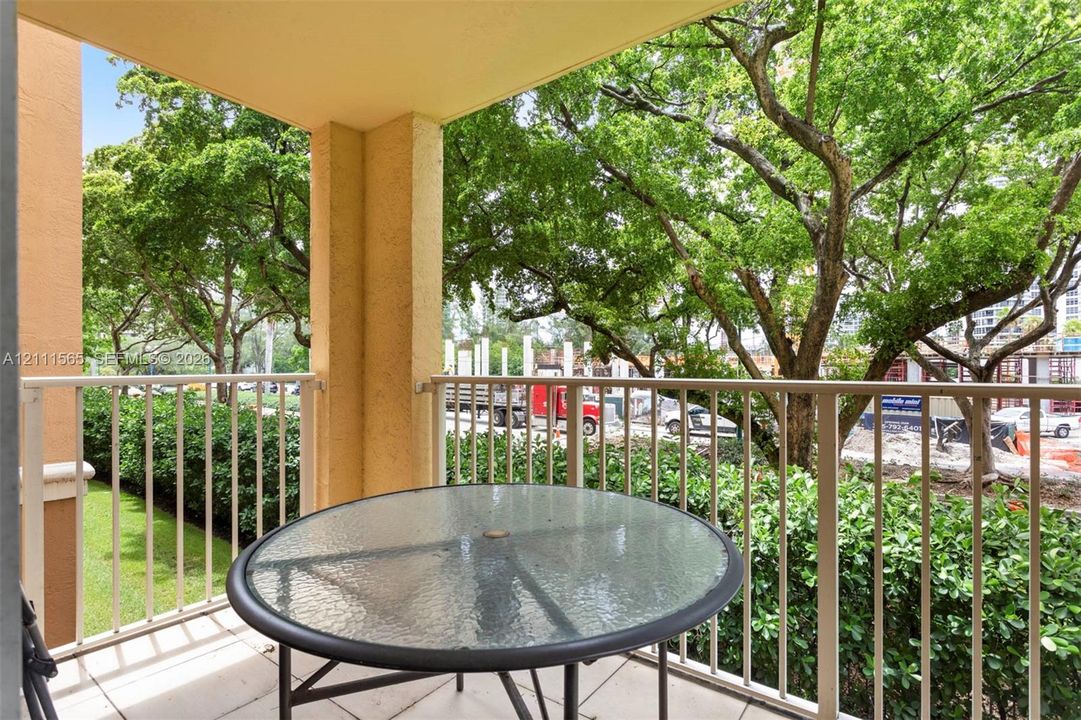 Covered balcony featuring tile flooring and a neutral metal railing