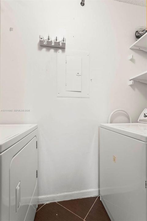 Utility area featuring built-in shelving and tile flooring