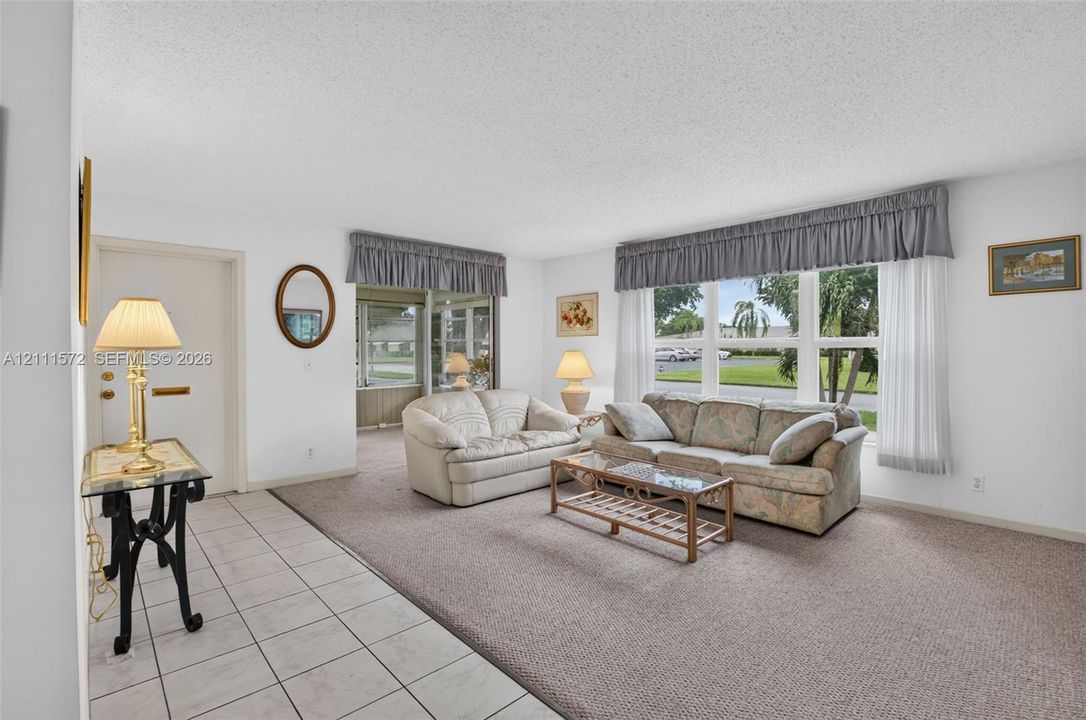 Neutral-toned ceramic tile flooring at entry, plush berber carpeting, and expansive multi-pane windows providing lots of natural light