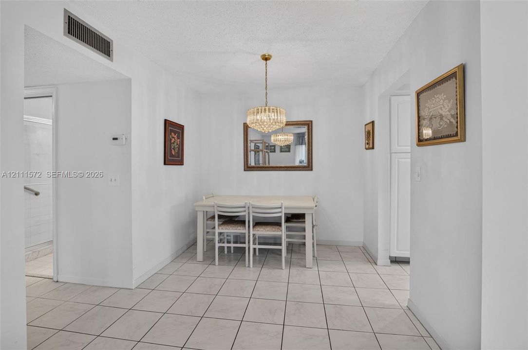 Dining area featuring, ceramic tile flooring and a tiered crystal chandelier
