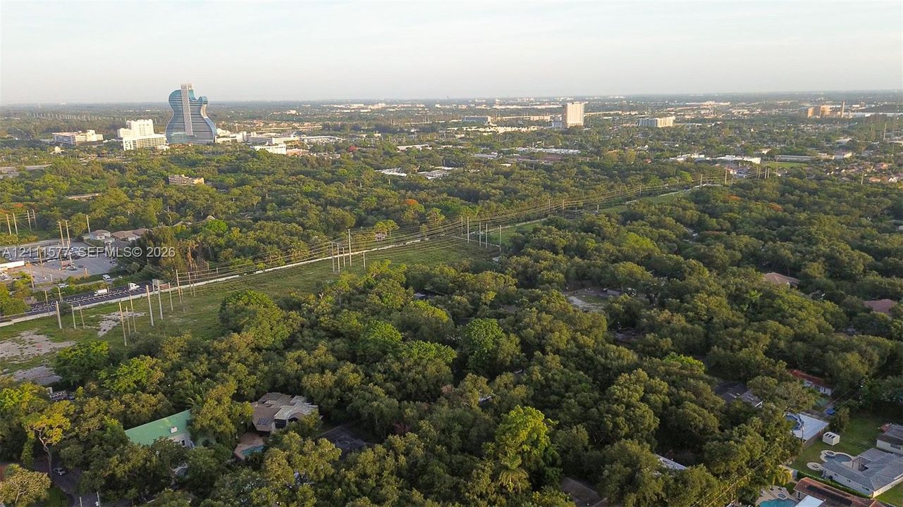Aerial perspective of a sprawling parcel featuring dense mature tree cover and expansive greenery