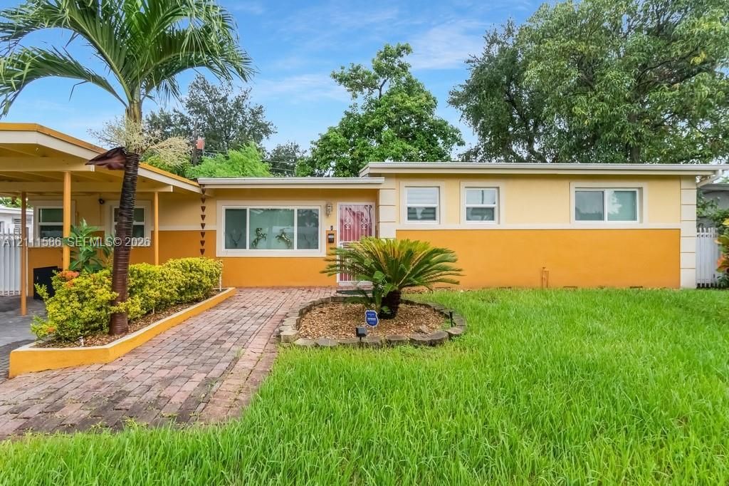Single-story exterior featuring a brick walkway, covered carport, and low-maintenance landscaping