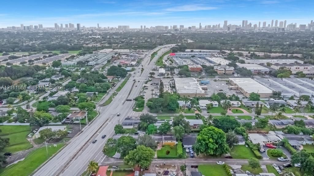 Aerial perspective showcasing urban skyline backdrops, mature tree canopy, and access to local thoroughfares