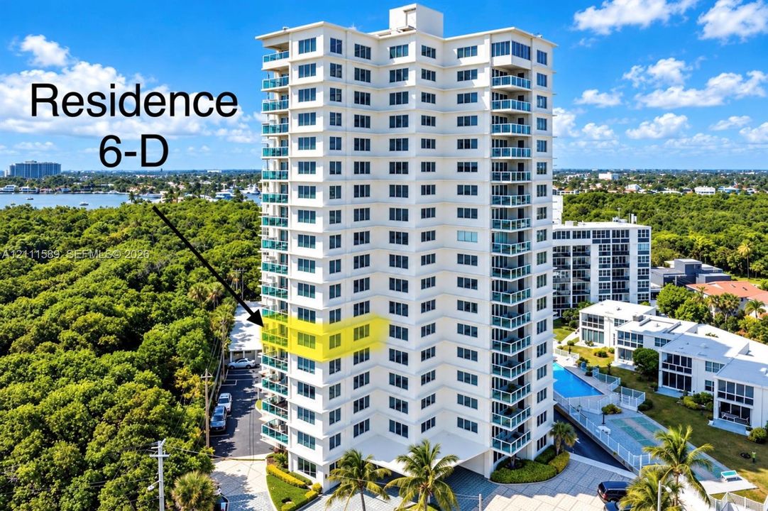 High-rise residential building featuring private balconies with glass railings, an exterior swimming pool, and dedicated paved parking