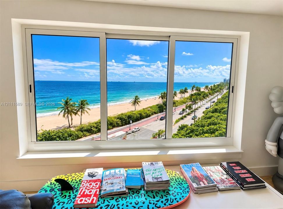 Expansive three-panel sliding window featuring a white frame and direct, elevated coastal scenery