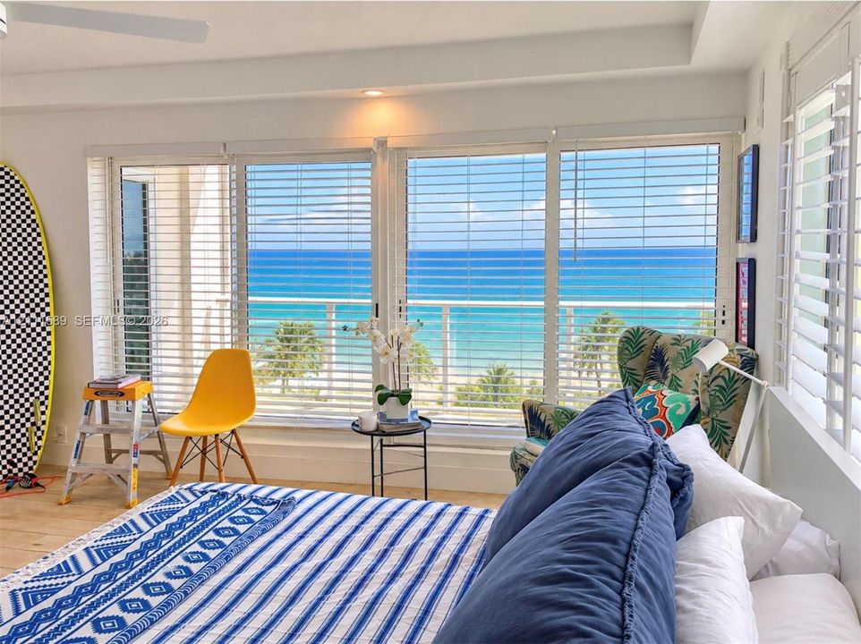 Floor-to-ceiling windows with horizontal blinds, wood-finish flooring, recessed lighting, and a private balcony