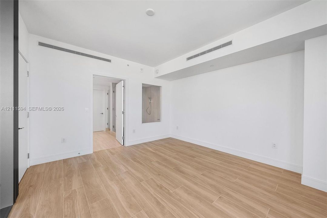 Minimalist interior featuring wood-finish flooring, recessed ceiling lighting, and a square wall niche