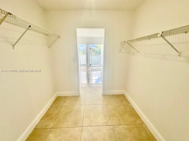 Storage area featuring ceramic tile flooring and dual-level wire shelving