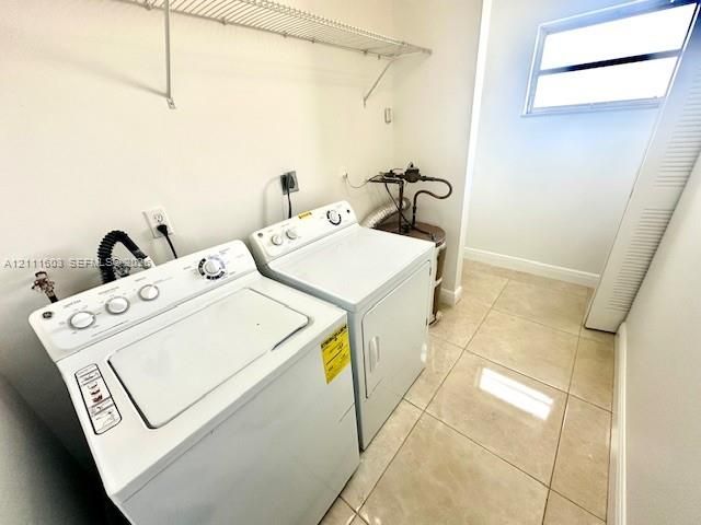 Utility space featuring tile flooring, a wall-mounted wire shelving unit, and a horizontal window