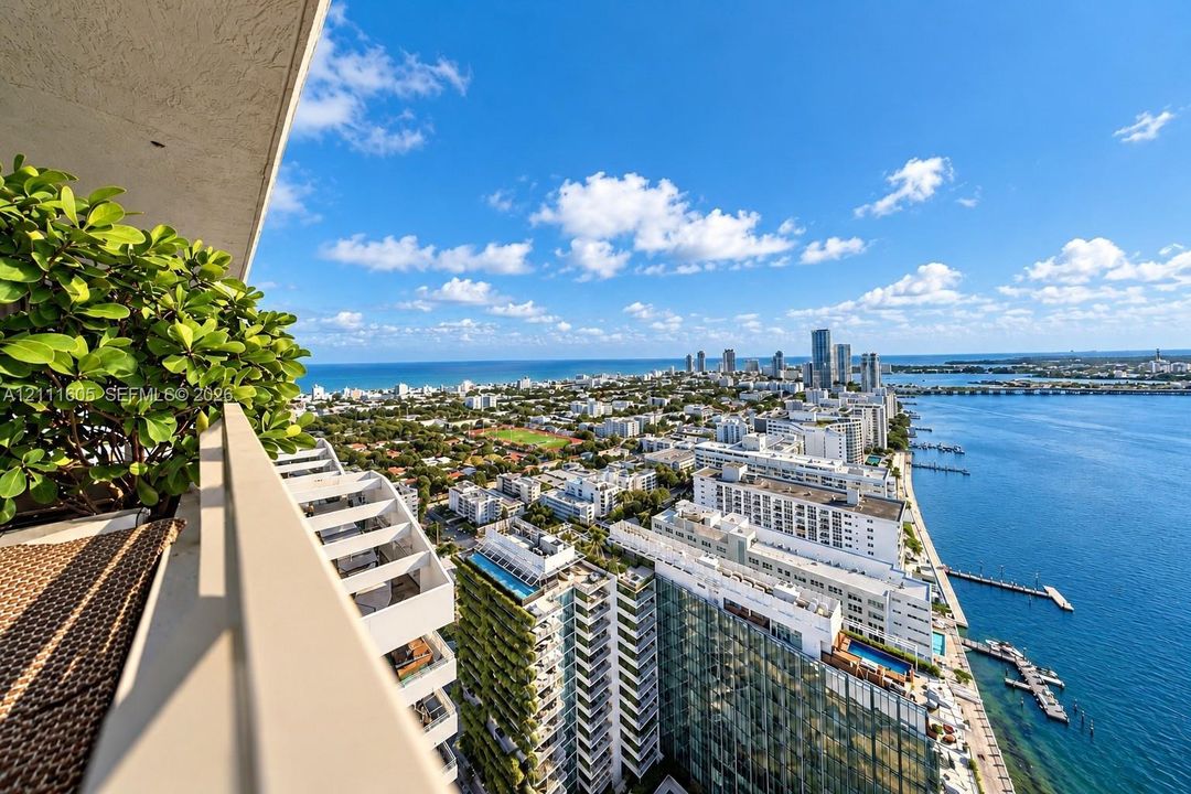Elevated terrace featuring a metal railing and panoramic coastal, city, and waterfront scenery