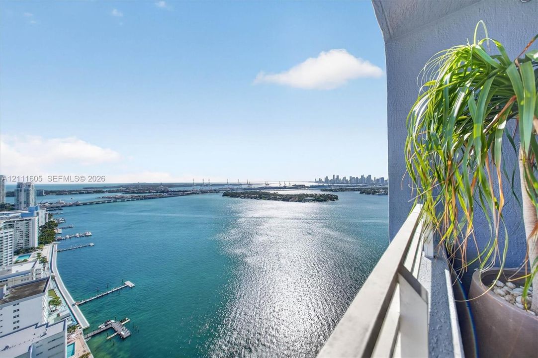Private balcony featuring a metal railing and expansive water, bridge, and cityscape backdrop