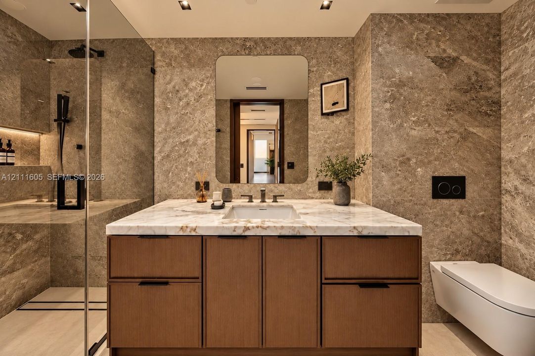 Custom wood-finish vanity with stone countertop, undermount sink, wall-mounted matte black fixtures, floor-to-ceiling stone wall tiling, and wall-mounted toilet