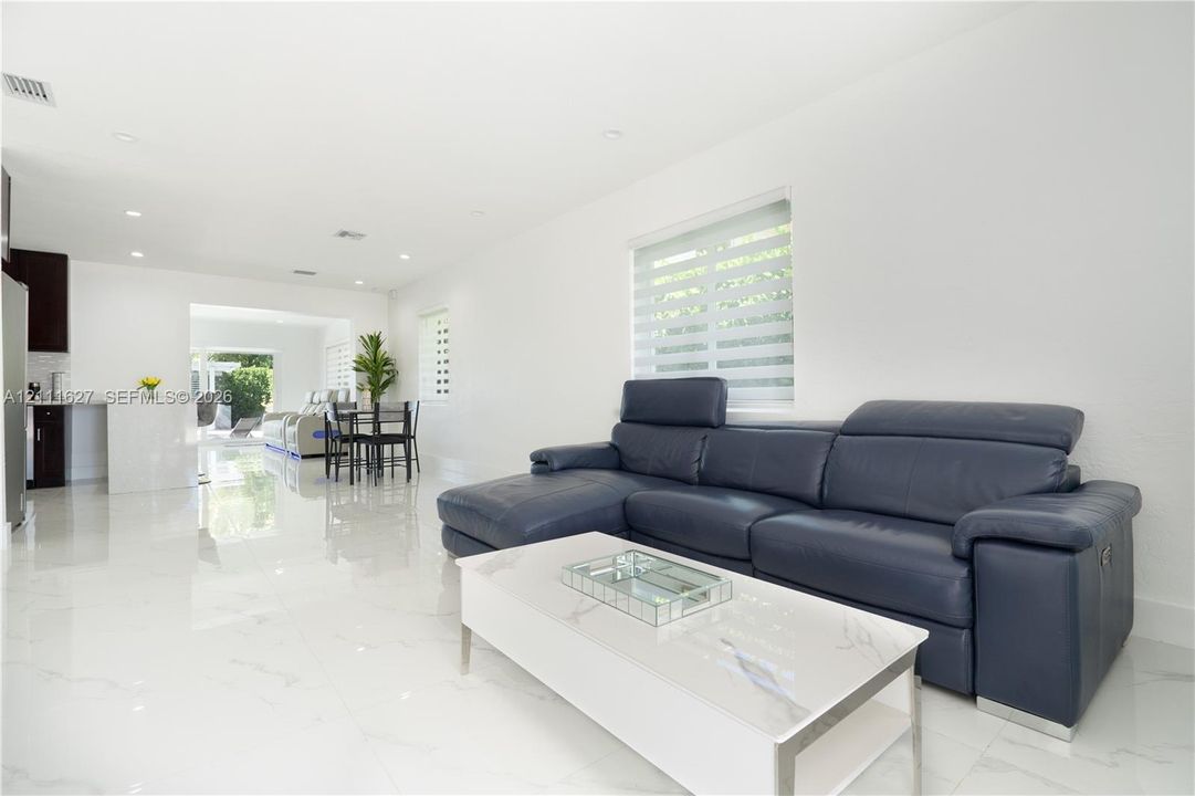 Large-format porcelain tile flooring, recessed ceiling lighting, and dual-layered window shades