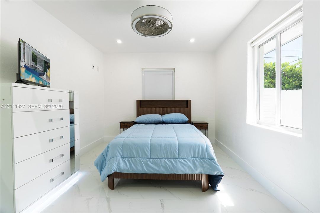 Interior space featuring polished white tile flooring, recessed lighting, and a contemporary circular flush-mount ceiling fan