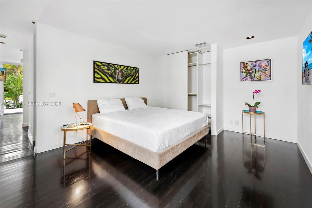 Dark wood-finish flooring, recessed lighting, and built-in closet with sliding doors