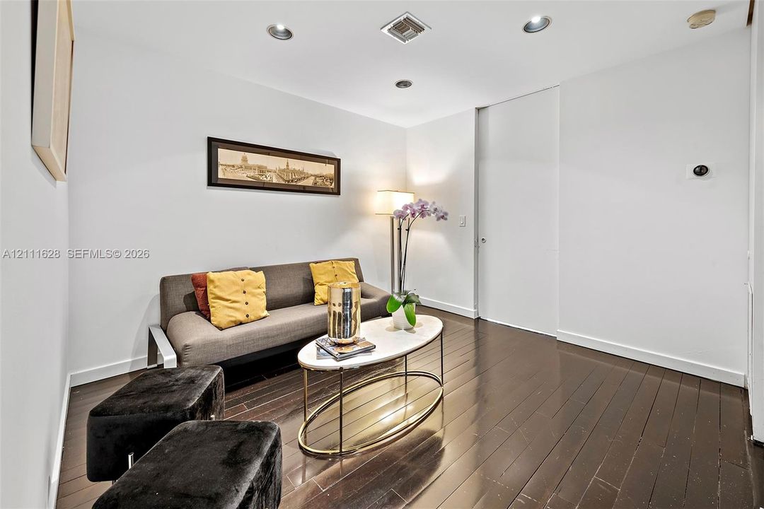 Wood-finish flooring, recessed lighting, and a full-height interior door