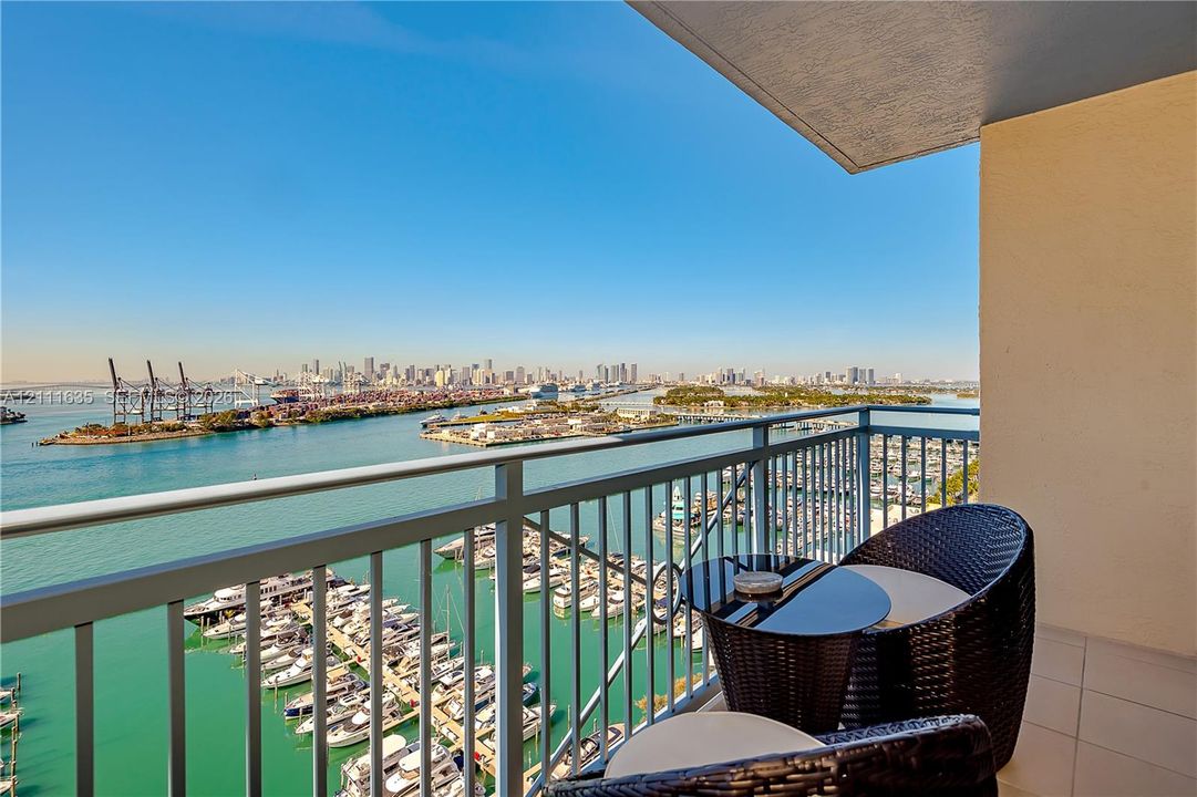 Private balcony with a metal railing, featuring large-format tile flooring and an overhead ceiling
