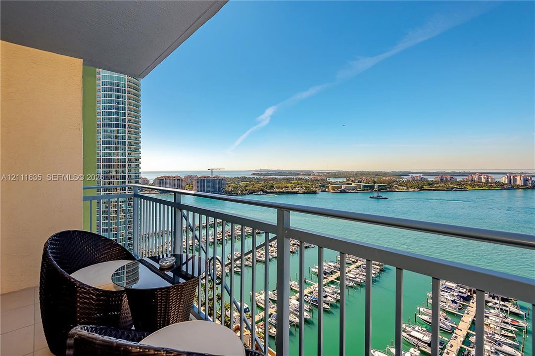 Private balcony featuring a metal railing and tile flooring overlooking the harbor and waterfront