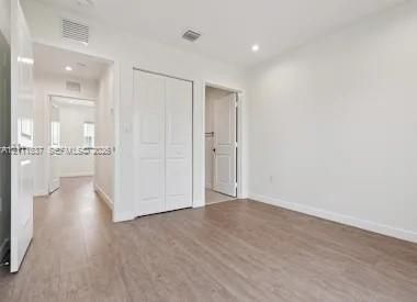 Interior space featuring wood-finish flooring, recessed lighting, and white paneled interior doors with bifold closet storage